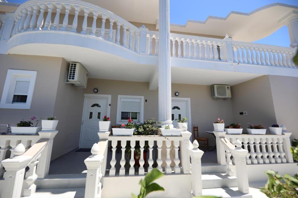 a white house with a staircase and potted plants at Guest House Narta in Vlorë