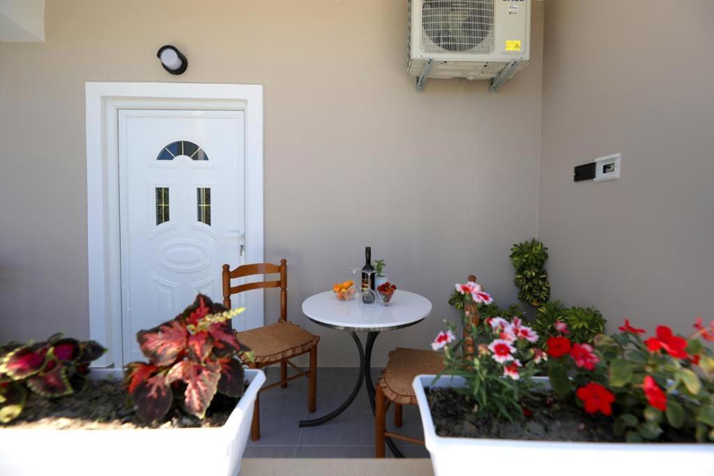 a room with a table and some flowers and a door at Guest House Narta in Vlorë