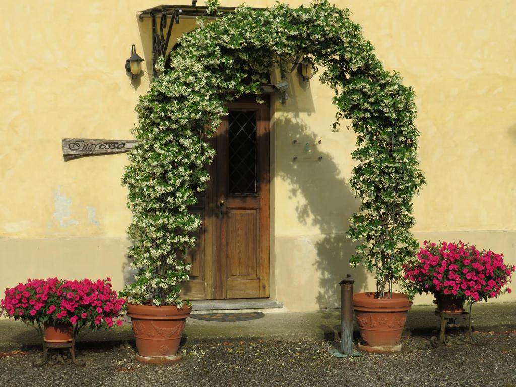 an arch with flowers inront of a door at Agriturismo Rivieraoglio in Piadena
