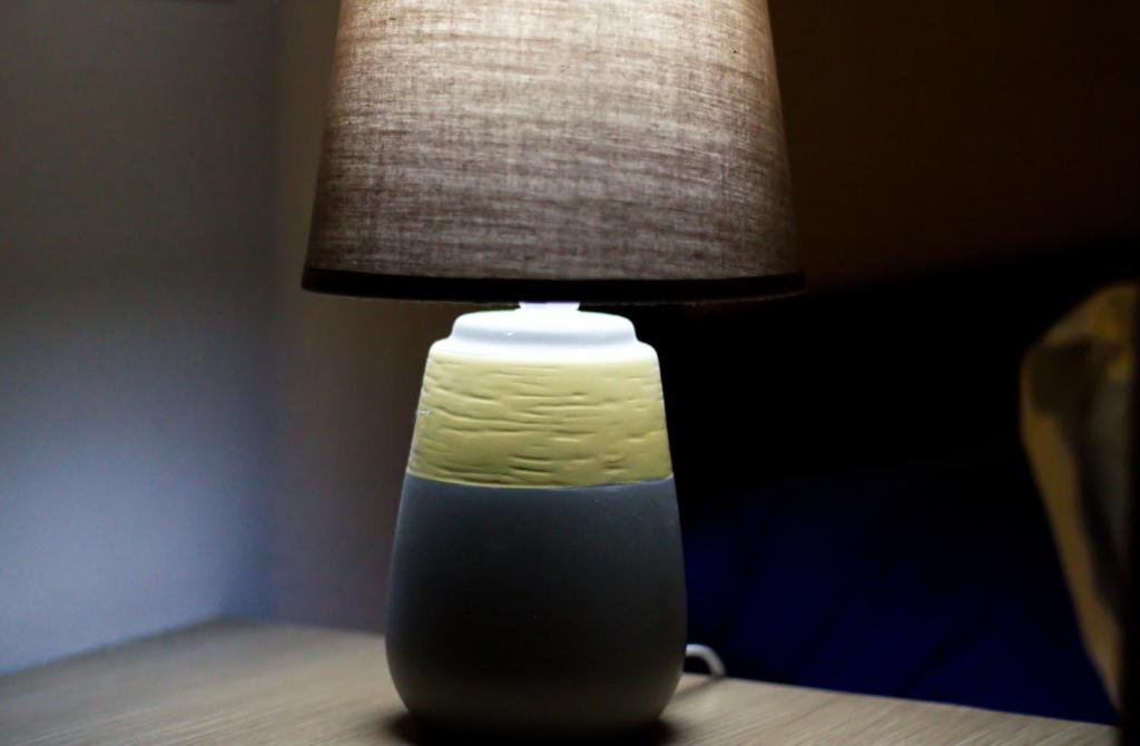 a green and white vase sitting on a table with a lamp at Kalamata Home #2 in Kalamata