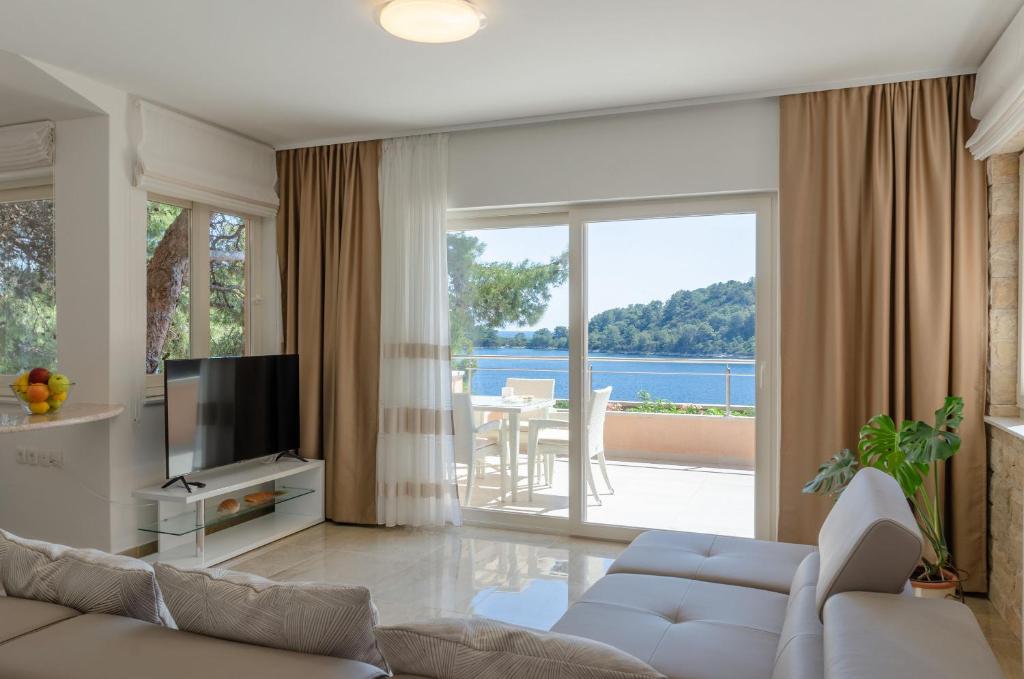 a living room with a couch and a large window at Pine Tree Apartment Zanetic in Blato