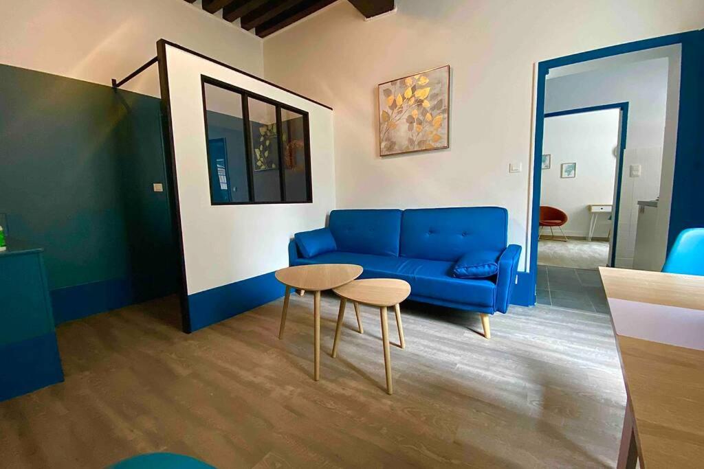 a living room with a blue couch and a table at Appartement de charme plein coeur de Moulins in Moulins