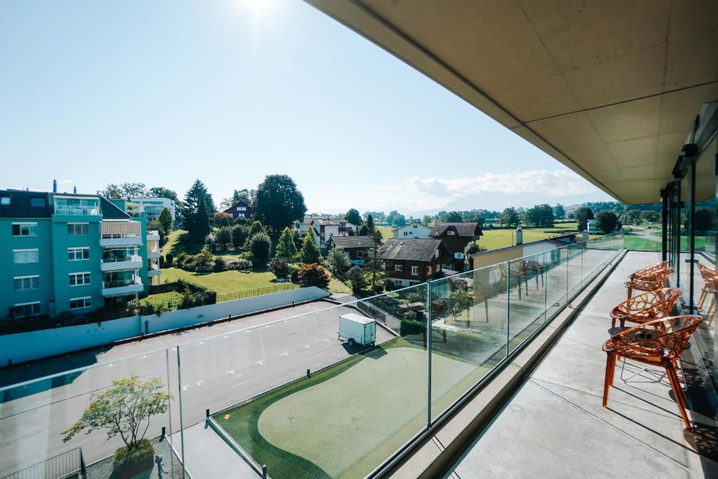 a balcony with a view of a tennis court at Hotel AVA in Sempach Station