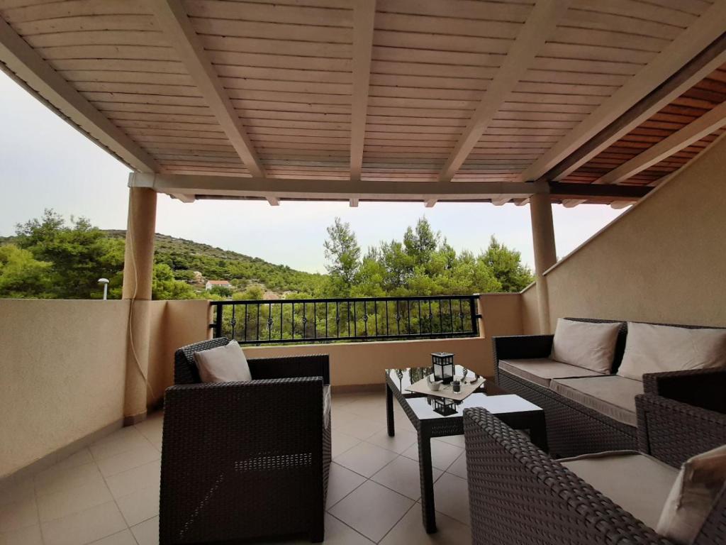 a patio with a couch and chairs and a table at Apartments Edo in Vis