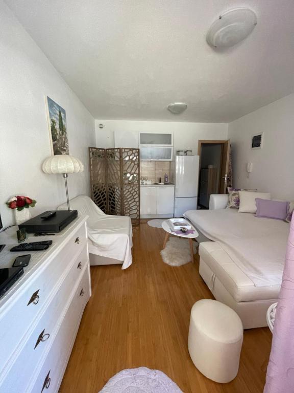 a living room with a bed and a couch at Perla Apartment Postira Island of Brač in Postira