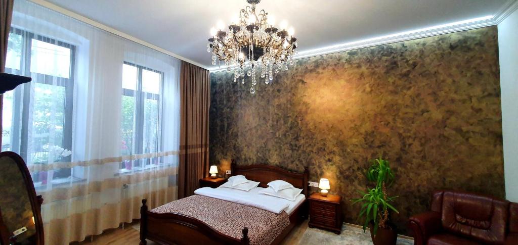 1 dormitorio con cama y lámpara de araña en Casa Domnească Rarau, en Câmpulung Moldovenesc