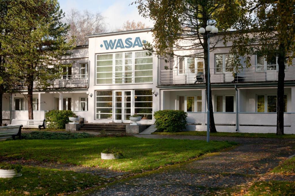 un bâtiment blanc avec un panneau indiquant une agence dans l'établissement Wasa Hotel & Health Center, à Pärnu