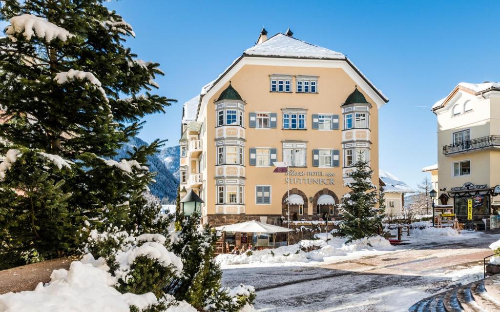 a large building with snow on the ground at Classic Hotel Am Stetteneck in Ortisei