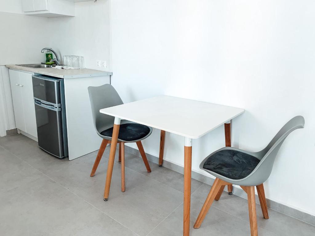 a white table and two chairs in a kitchen at Fabrica Sunset Apartments in Megali Ammos