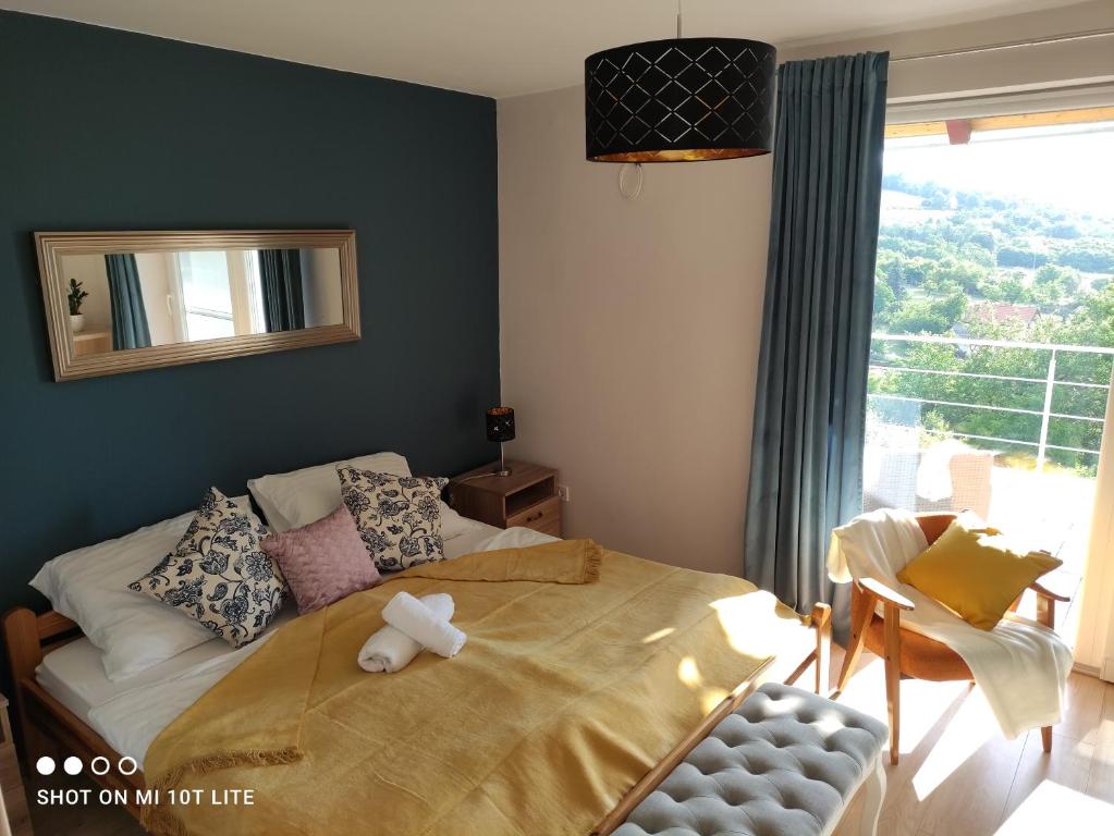 Un dormitorio con una cama con un osito de peluche. en Lívia nyaraló Szigliget en Szigliget