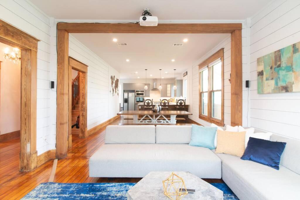 a living room with a white couch and a kitchen at Bachelor/Bachelorette Weekend in the Heart of ATX in Austin