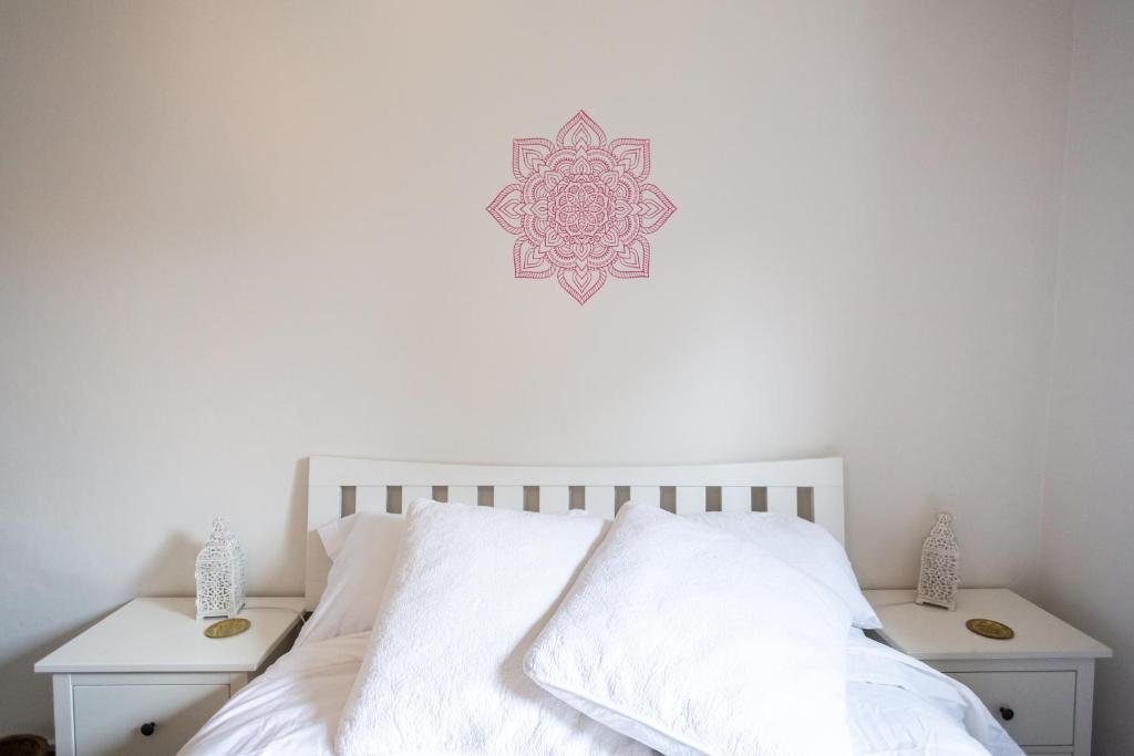 a bedroom with a white bed with a mandala on the wall at CloudZen in Kent
