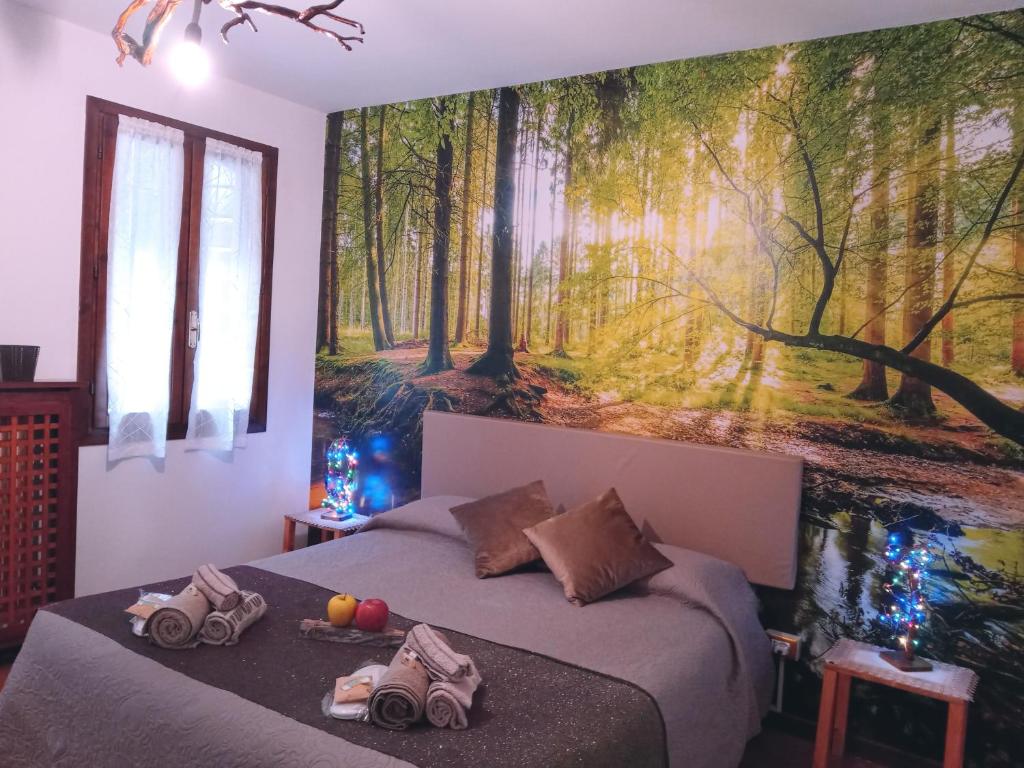 1 dormitorio con 2 camas y un mural de bosque en la pared en Montegrappa Fly on, en Crespano del Grappa