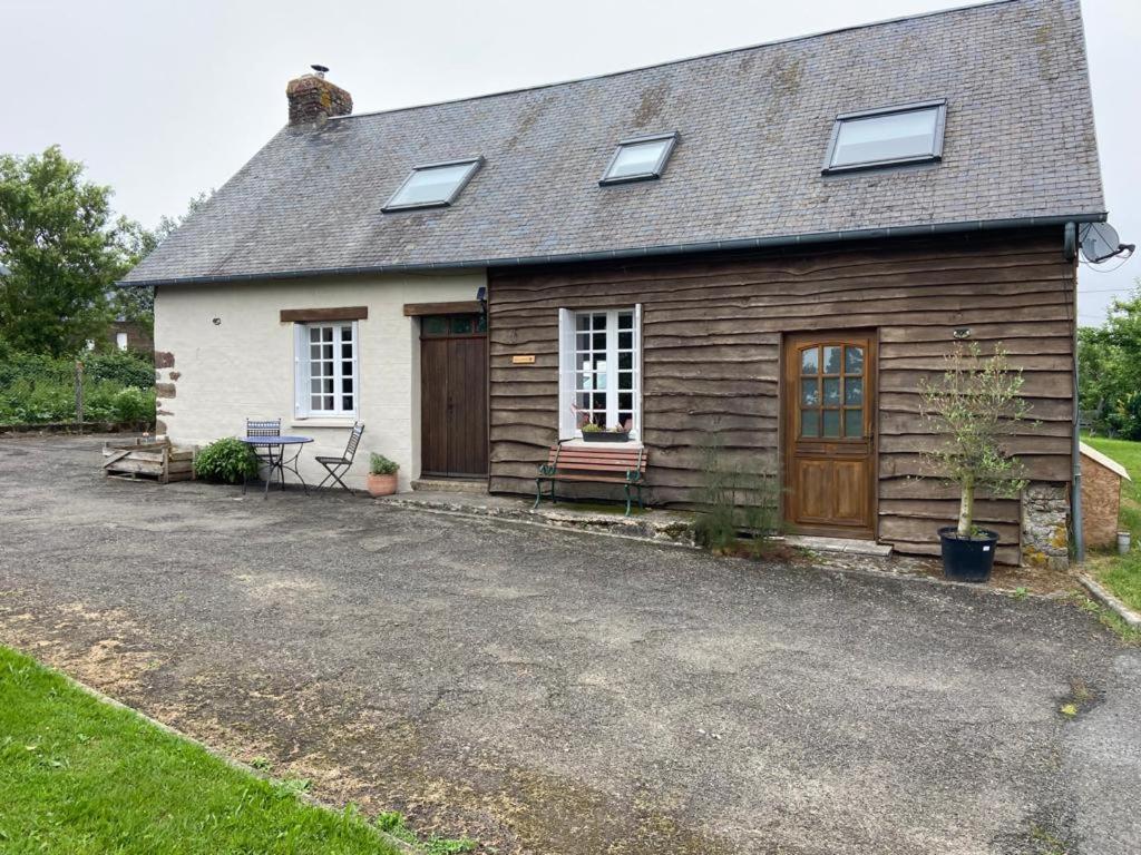 a house with a gravel driveway in front of it at Gîte La Roche in Reffuveille