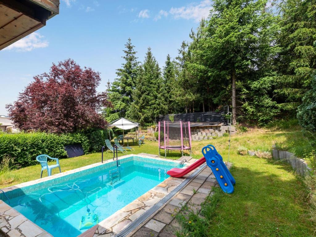 a pool with a slide and a playground in a yard at Ruhige Gartenwohnung in Dresden in Dresden