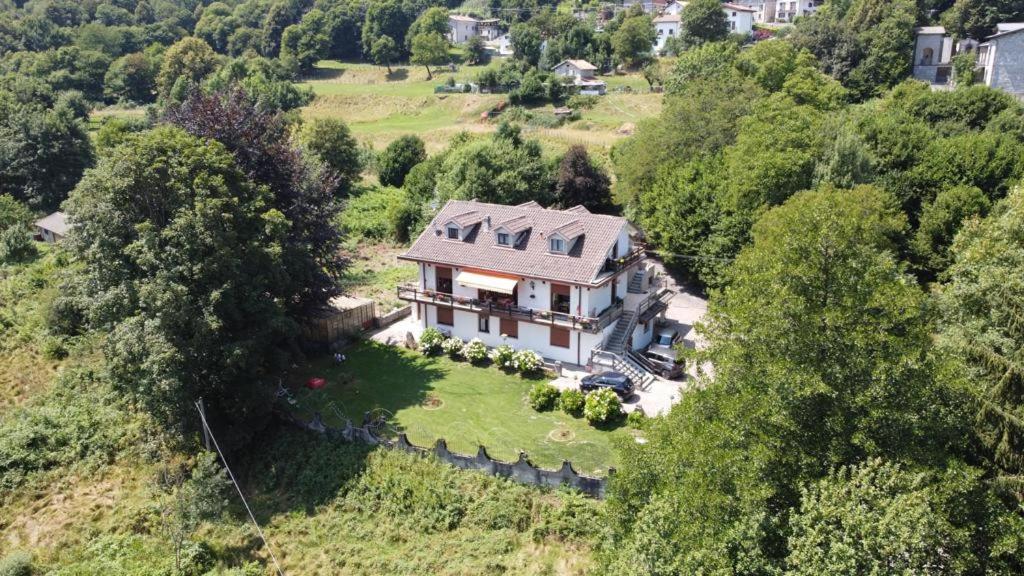 Vue aérienne d'une maison sur une colline dans l'établissement Villa immersa nel verde a Lanzo d'Intelvi, à Lanzo dʼIntelvi