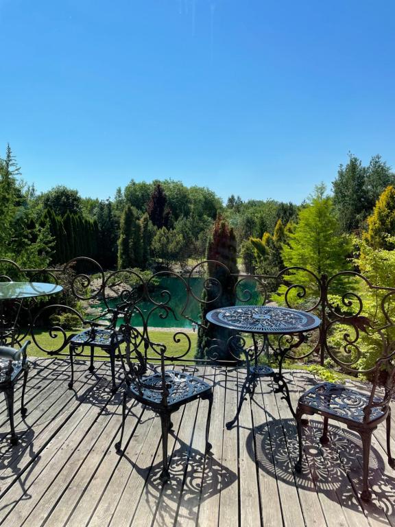un gruppo di sedie e tavoli su una terrazza di Pool Villa with japanese garden a Kaunas