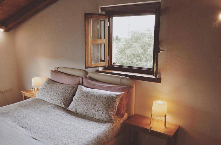a bedroom with a bed and a window at La Casa Griunit in Capriva del Friuli