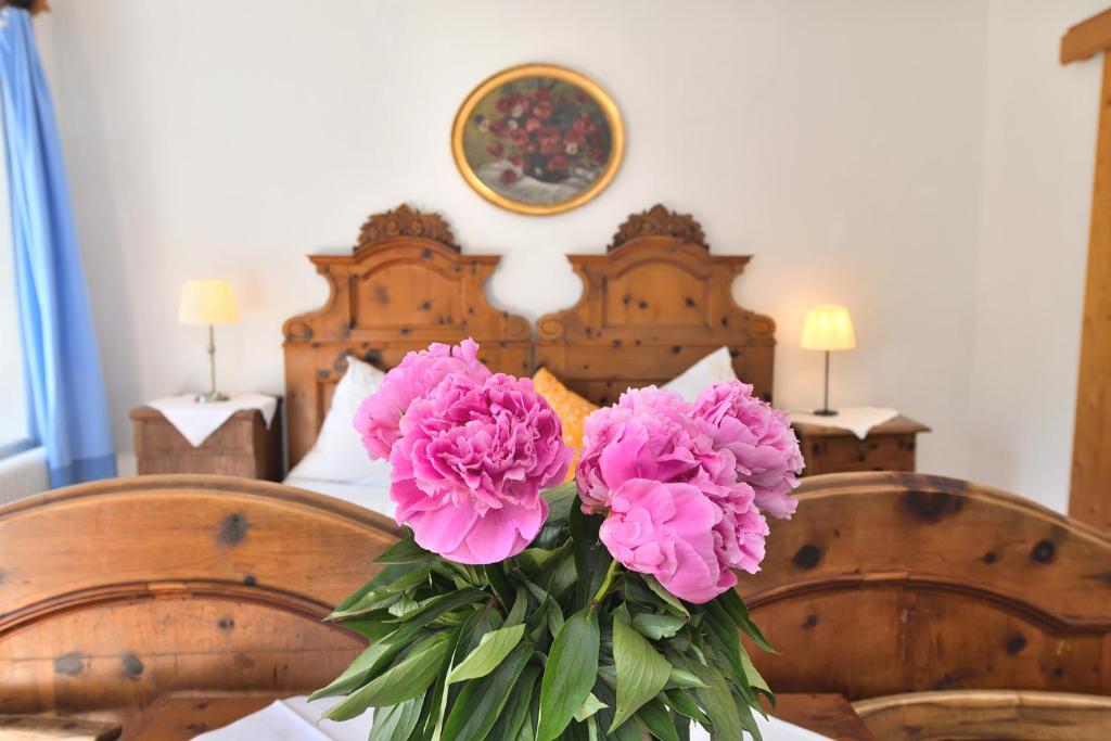 a vase of pink flowers sitting on a table at Gasthof Simony Hallstatt B&B in Hallstatt