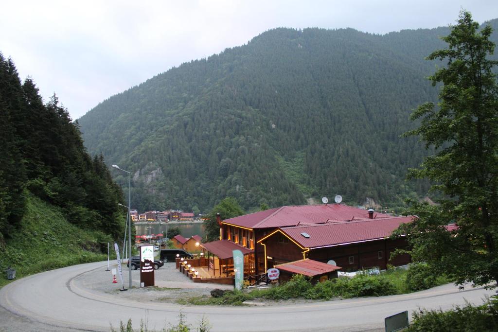 a building on the side of a road with a mountain at Faraksi Bungalow & Otel in Uzungol