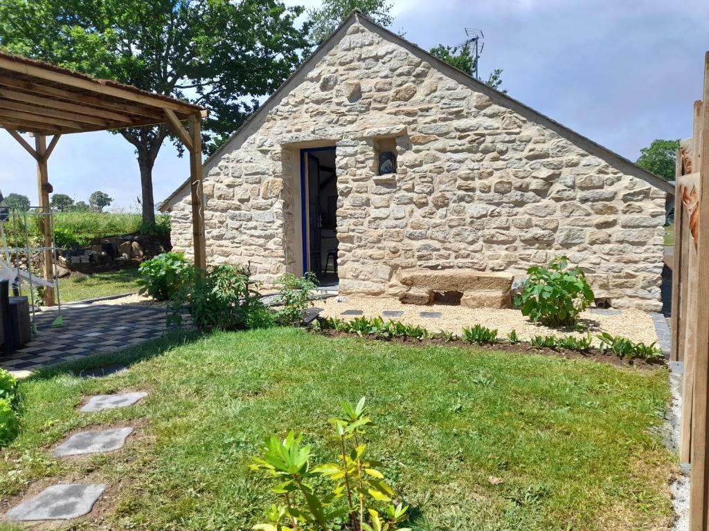 un granero de piedra con un patio de hierba delante de él en Ty Sau Hiol, La Moniclair en Péaule