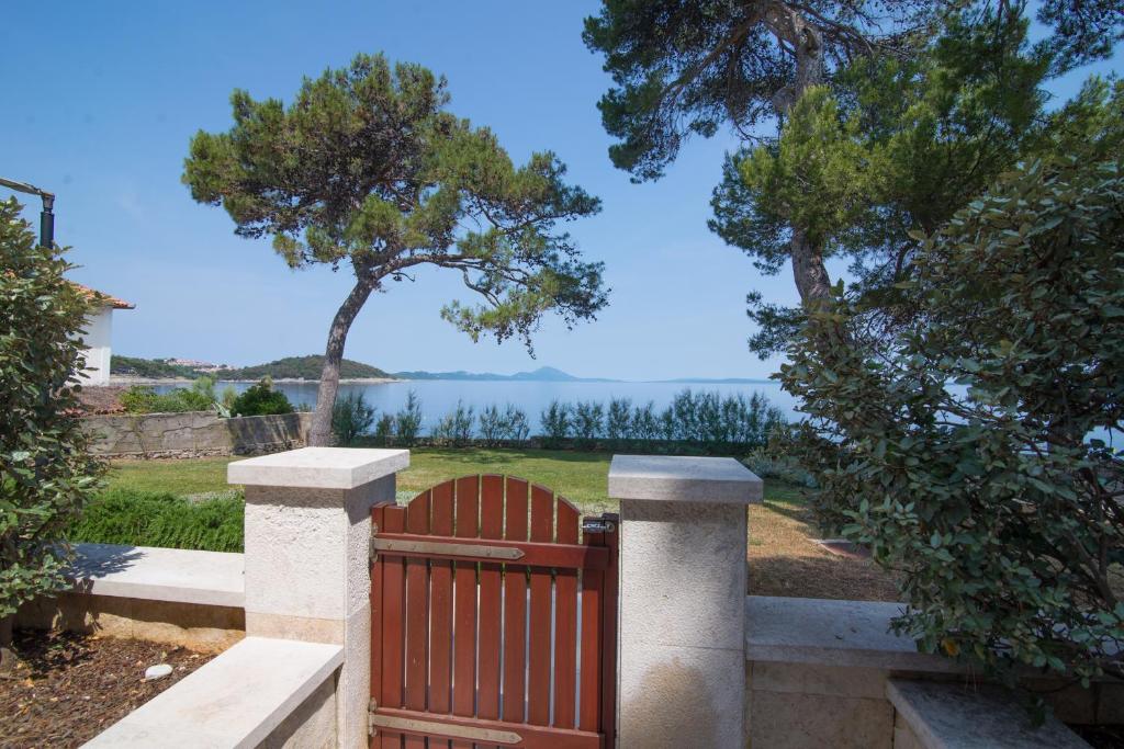 a wooden gate with a view of the water at Jelena B4 in Veli Lošinj