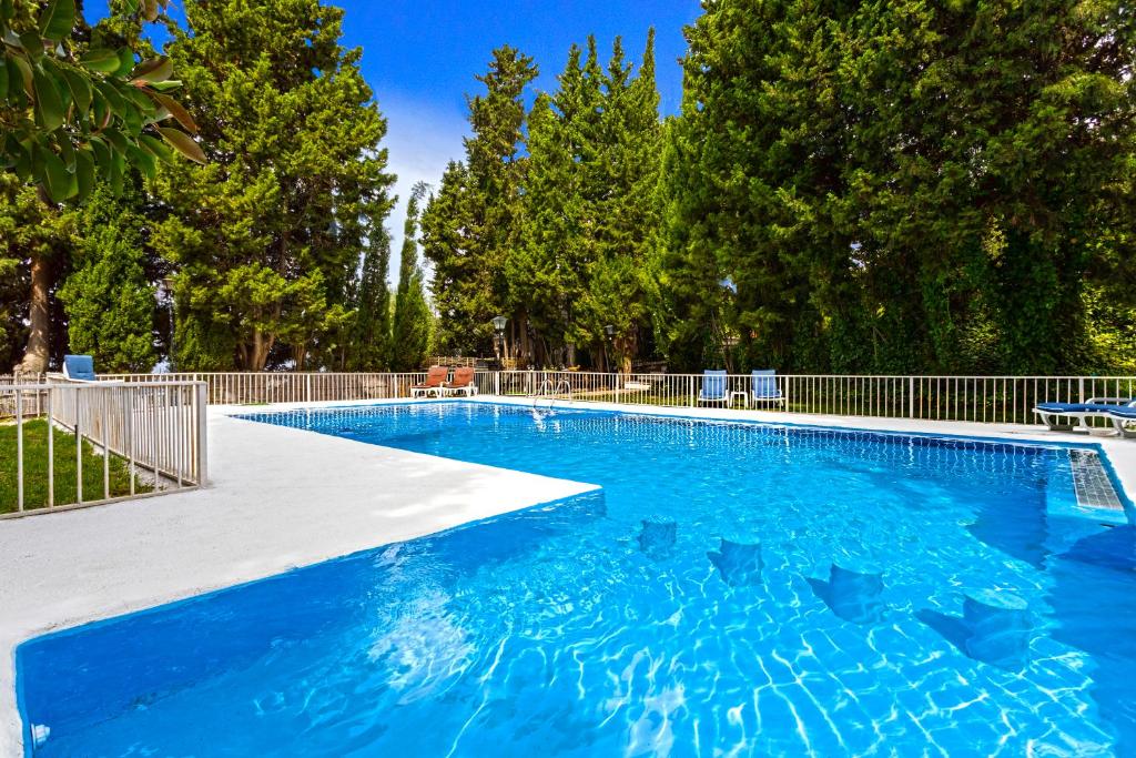a large swimming pool with blue water in a yard at Holiday Home El Alcázar in Alcaucín