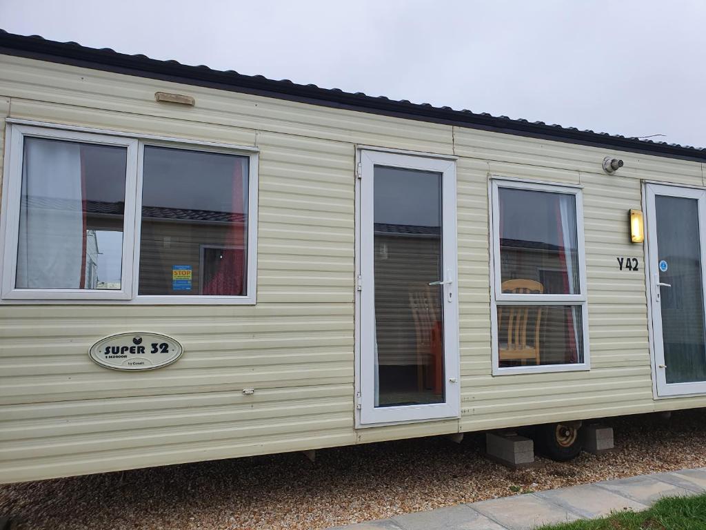 a beige trailer with windows on the side of it at J & F caravan in Skegness