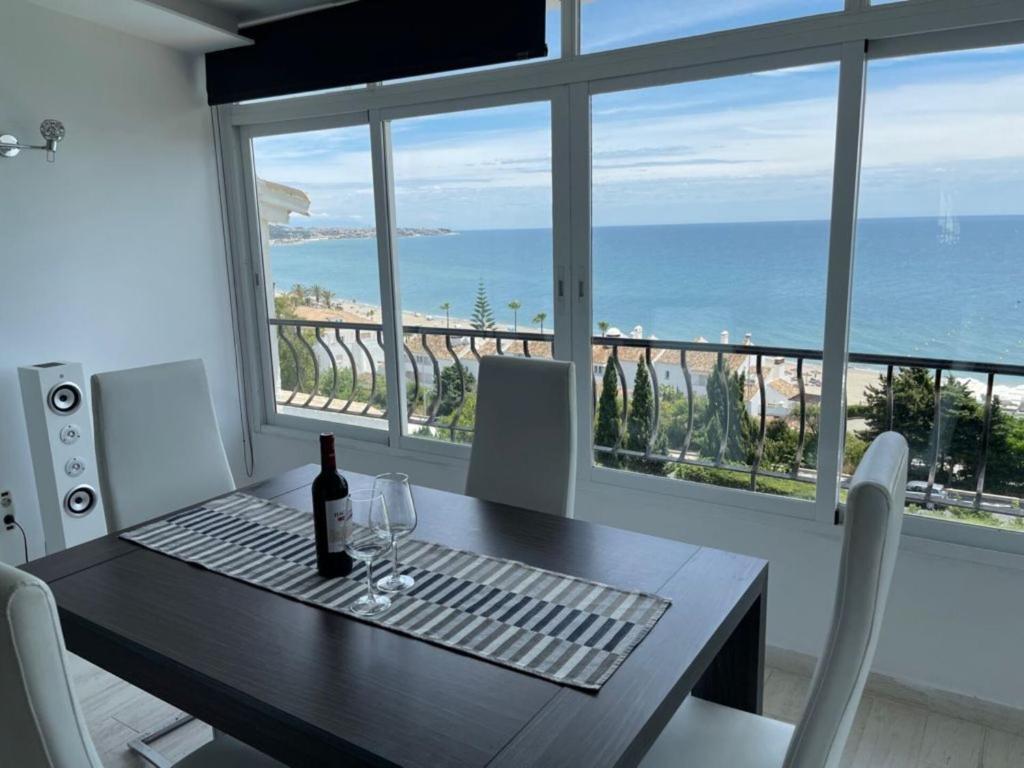 a dining room with a table with a bottle of wine at Modern Apartment with sea view close to Marbella in Mijas