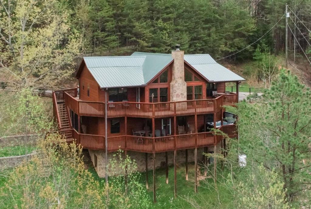 a large wooden house on a hill with trees at BareFoot Cabin cabin in Sevierville