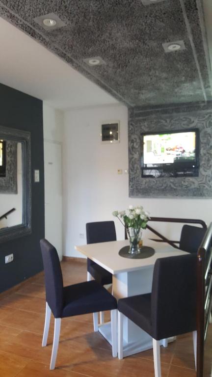een eetkamer met een tafel en stoelen en een televisie bij Guesthouse Vladimir & Ana in Pančevo