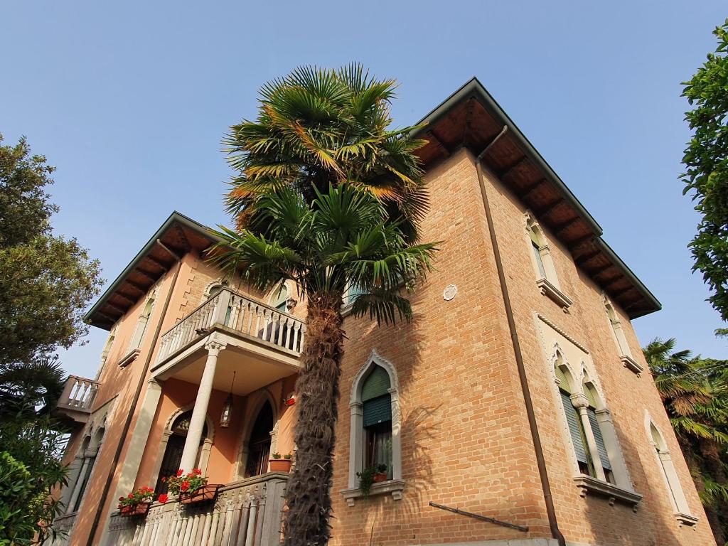 a palm tree in front of a building at villa berghinz in Venice-Lido