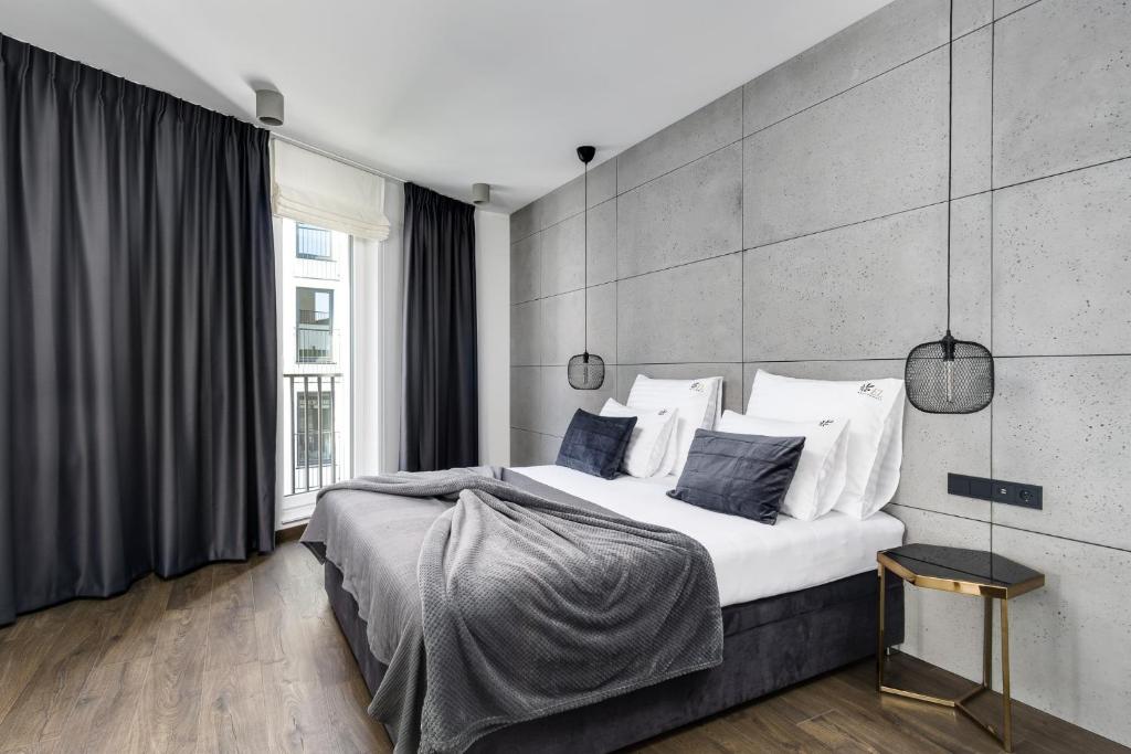 a bedroom with a large bed with white sheets and pillows at EL Apartments - Hercules in Poznań