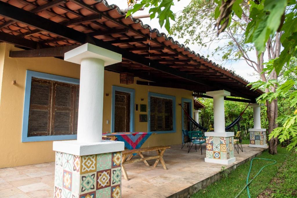 a patio of a house with a pergola at Chalé Aroeira Taiba in Taíba