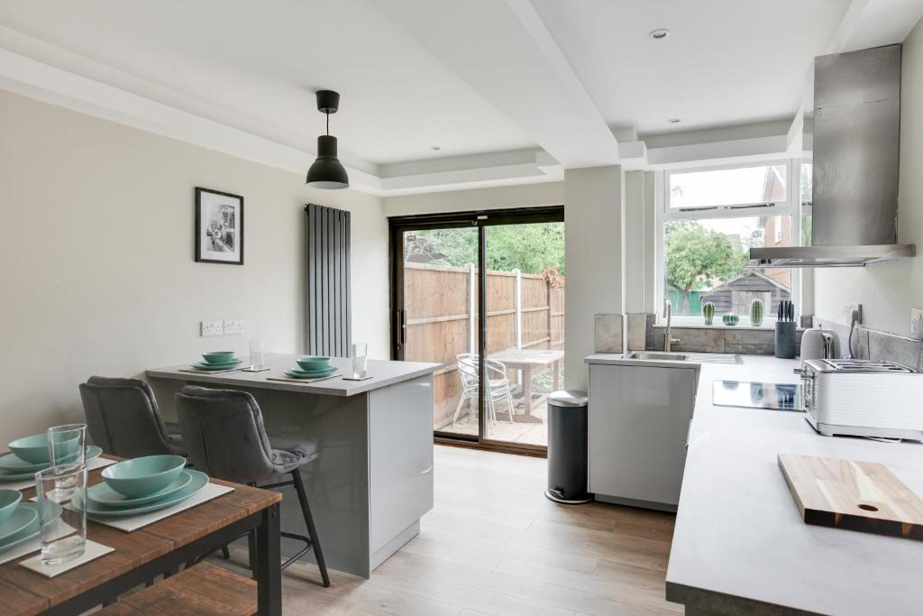 cocina con mesa, sillas y barra en Spacious, Modern Three Bed House - Free Parking & Wifi en Chelmsford