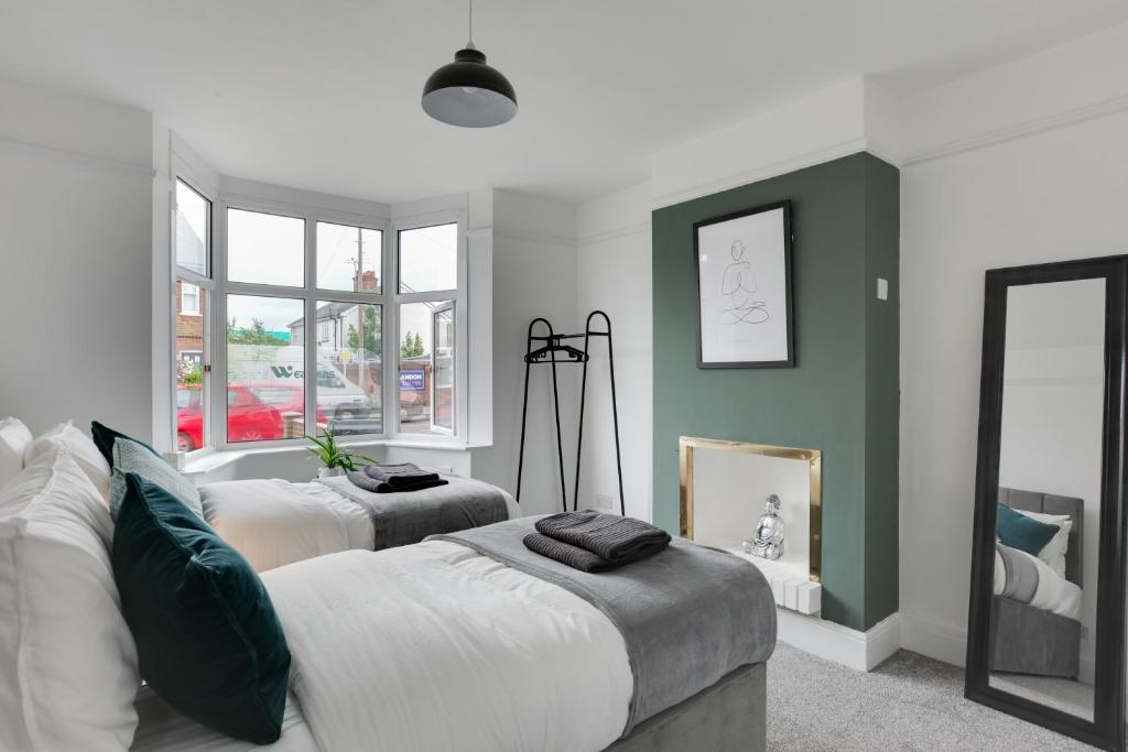 1 dormitorio con 2 camas y espejo en Spacious Three Bed Central Chelmsford House - Free Parking & Wifi, en Chelmsford
