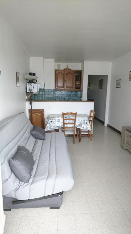 une chambre avec un lit, une table et des chaises dans l'établissement APT FRONT DE MER DANS RESIDENCE LUXE SECURISEE, à Banyuls-sur-Mer
