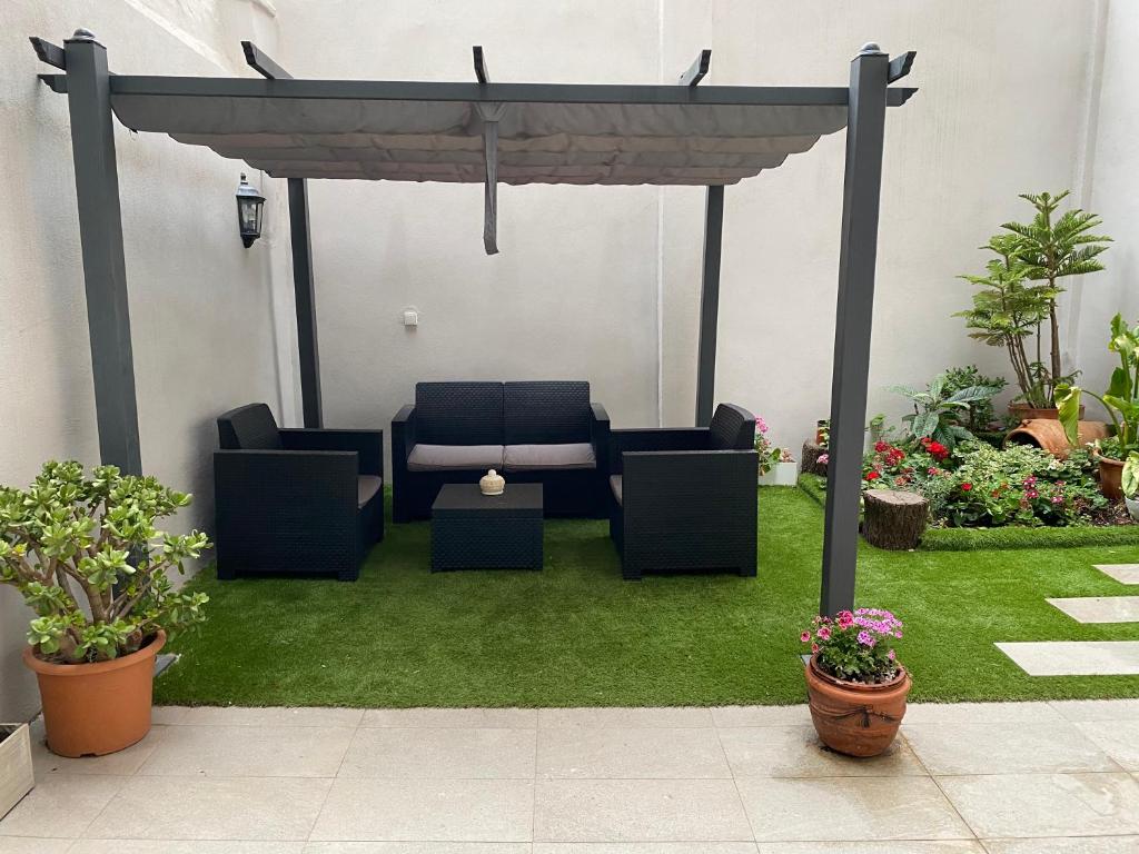 a pergola with chairs and a table in a yard at Camp Nou Nueva Casa in El Arrabal
