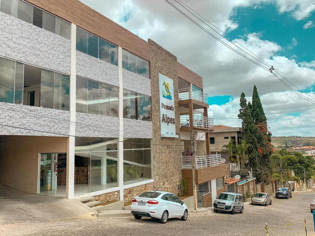 a building with cars parked in front of it at Pousada Alpes in Triunfo