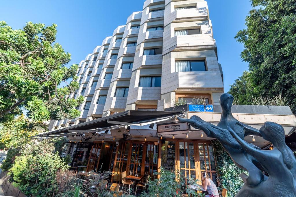 uma estátua em frente a um edifício em 130 Rock Apartments em Tel Aviv