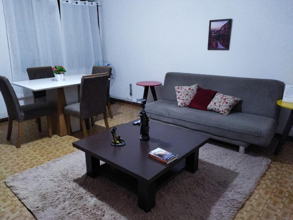 Apartamento Bento Residence في أوروغويانا: غرفة معيشة مع أريكة وطاولة