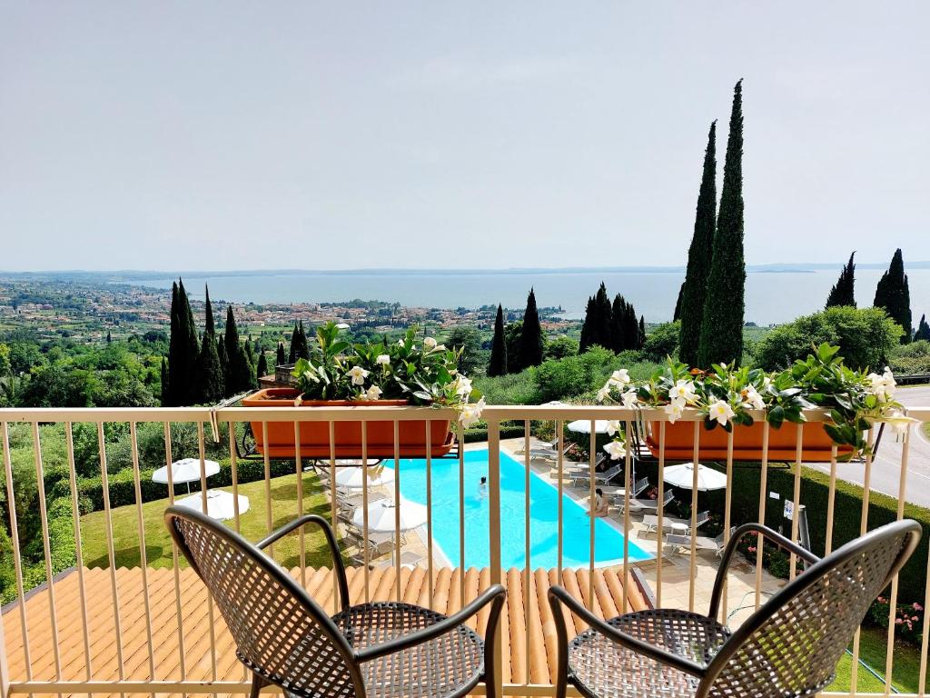 balcone con sedie e piscina di Hotel Valbella a Bardolino