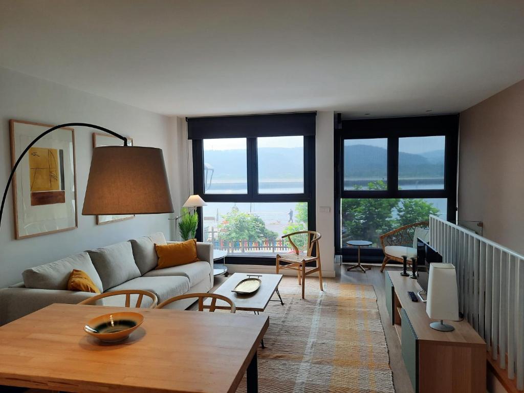 San Esteban de Pravia的住宿－Apartamentos Casa La Rambla，客厅配有沙发和桌子