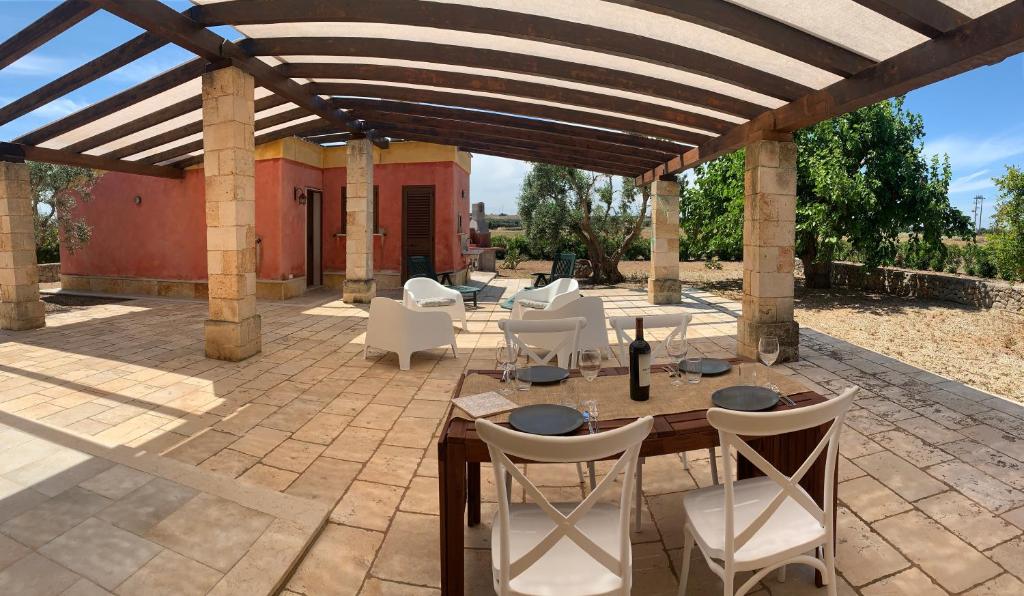 d'une terrasse avec une table et des chaises sous une pergola. dans l'établissement Villa Elena by ApulianBnV, à Serranova