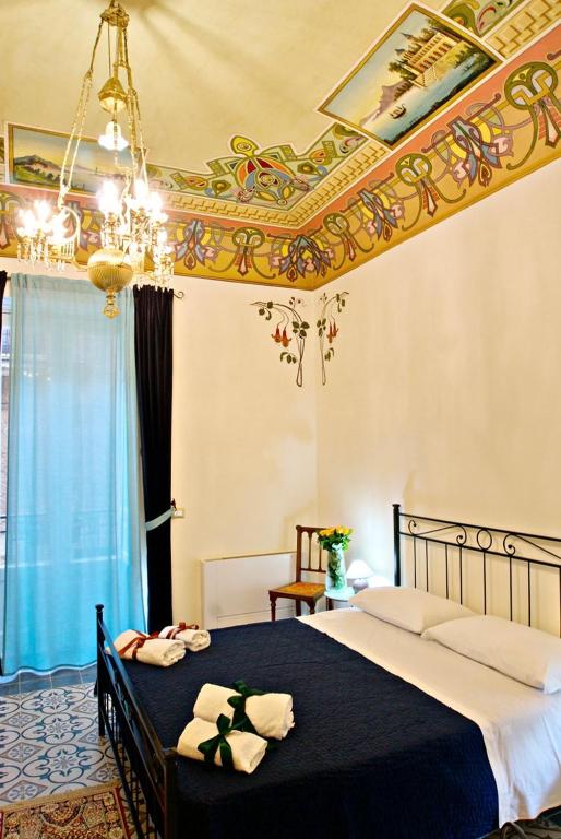 sypialnia z dużym łóżkiem i żyrandolem w obiekcie Domus Aurea w mieście Montalbano Elicona