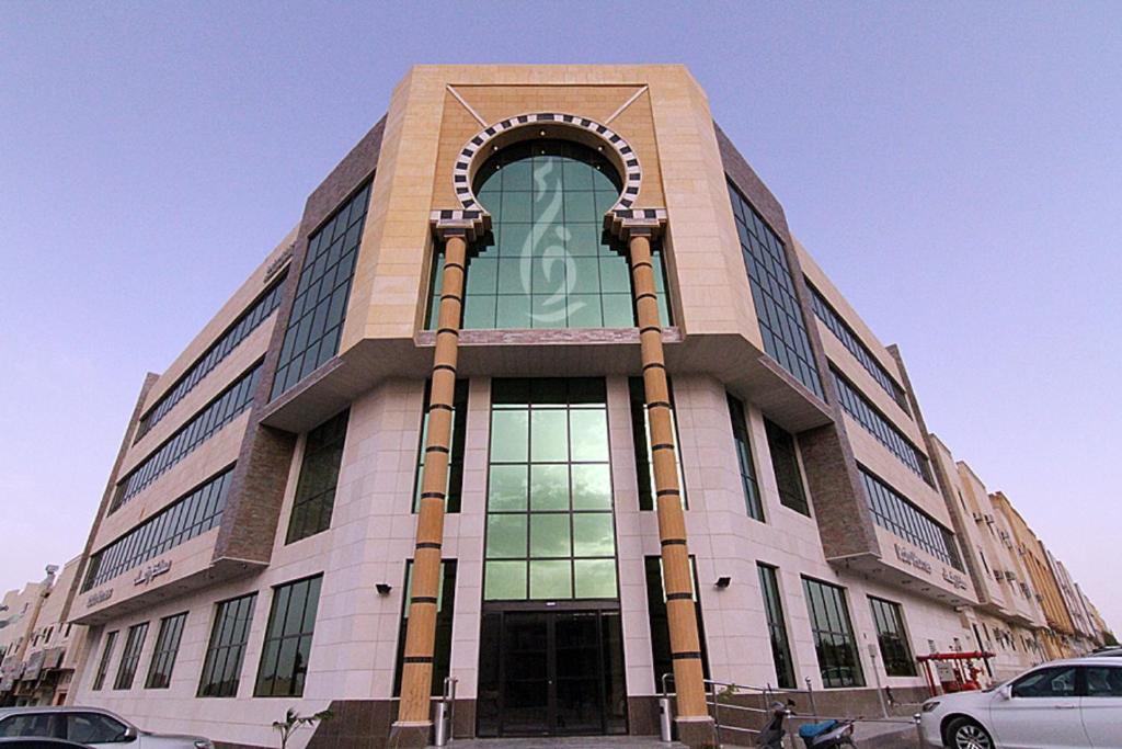 リヤドにあるRafa Homesのアーチ型の窓のある大きな建物