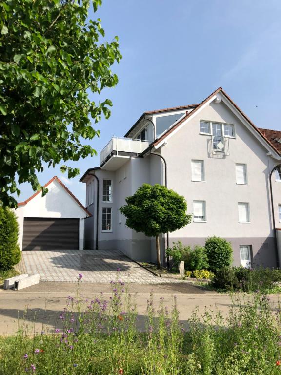 a large white house with a driveway at Ferienwohnung Limes am Kocher in Hüttlingen