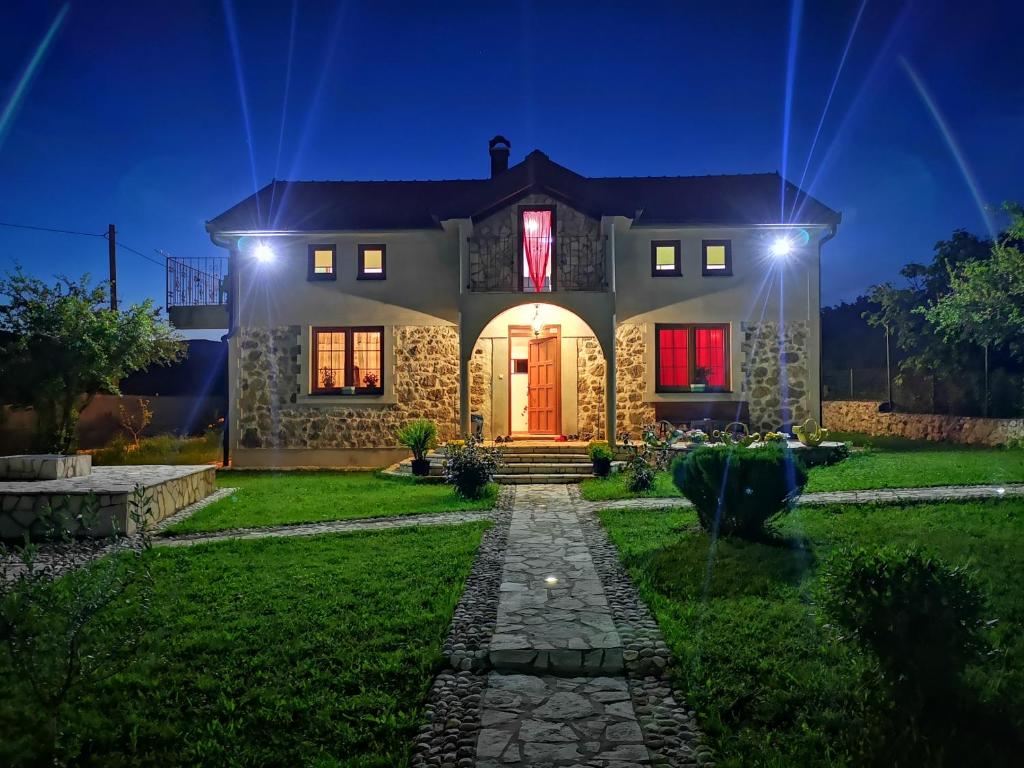 a house with a red door at night at Silent Village Villa with Swimming Pool in Mostar