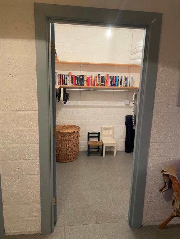 a door leading into a room with a book shelf at Mill House Studio Apartment in Stranocum