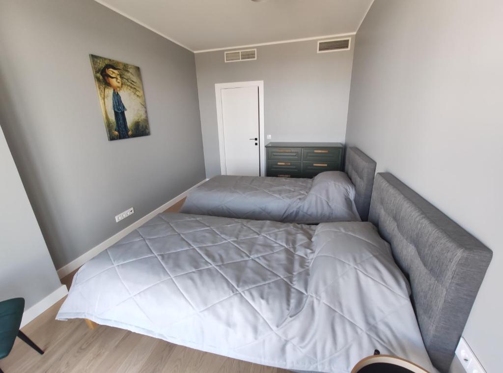 ein Schlafzimmer mit einem Bett und einem Wandgemälde in der Unterkunft SEA GATE APARTMENT 20th floor in Klaipėda
